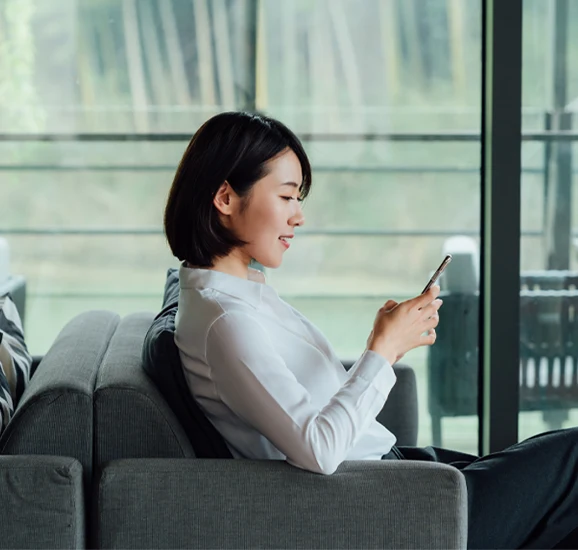 Frau mit Smartphone auf dem Sofa